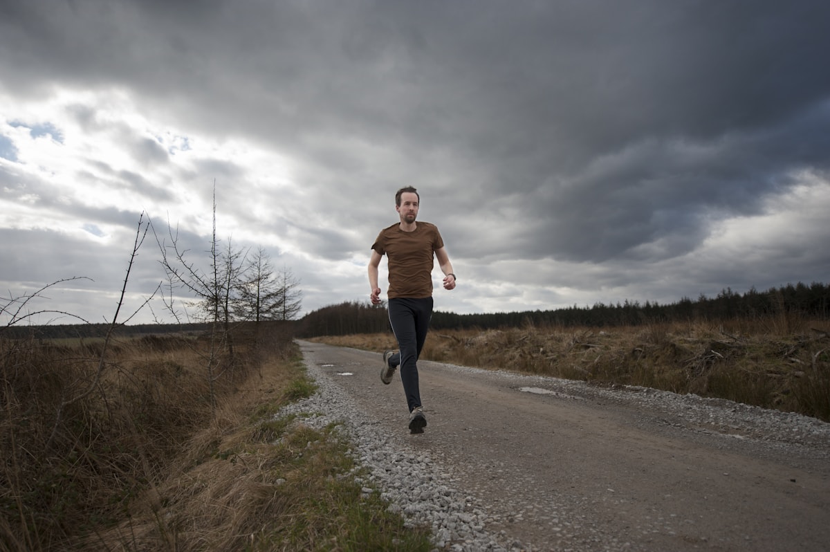 Hombre corriendo por un camino al aire libre.
