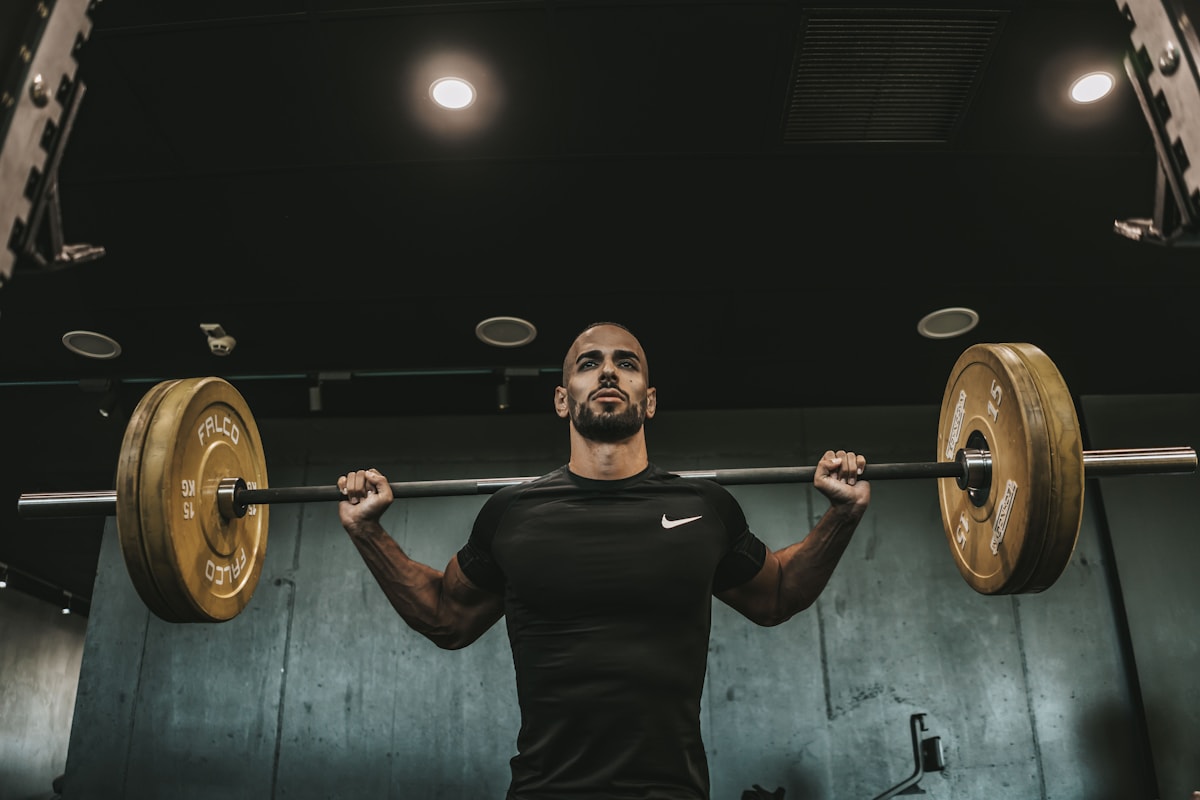 Hombre entrenando con una barra en un gimnasio.